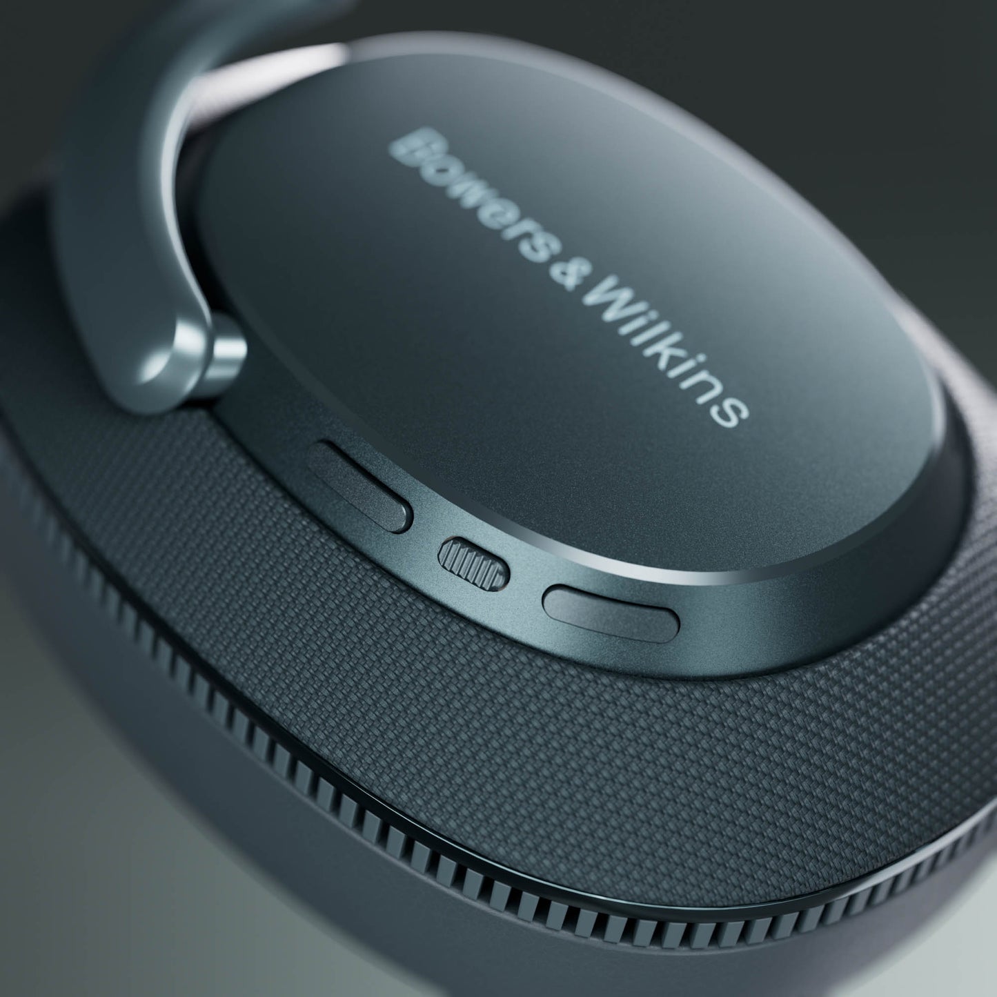 Close-up of a pair of headphones with 'Bowers & Wilkins' branding on a dark background