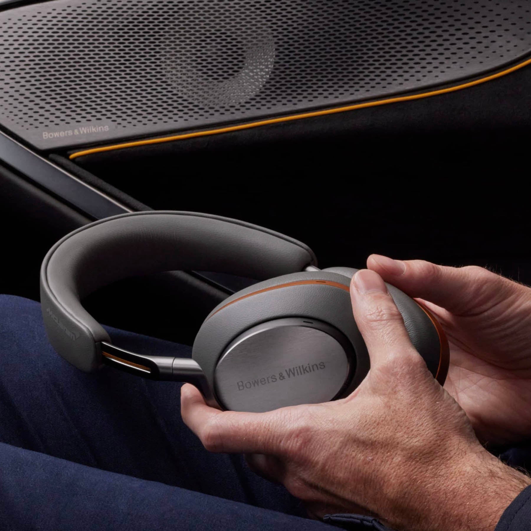 Person holding Bowers & Wilkins headphones with a car interior background