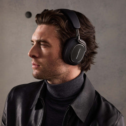 Man wearing black headphones against a gray background