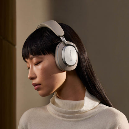 Woman wearing a pair of headphones against a neutral background