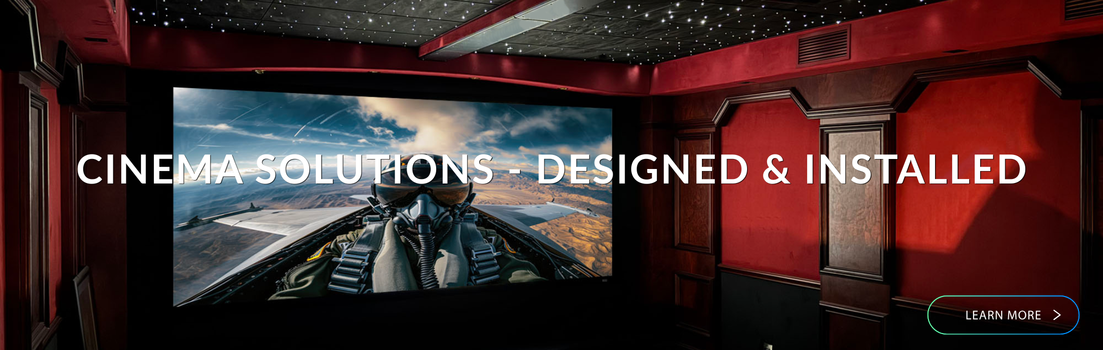 Home cinema setup with a large screen displaying a movie scene, surrounded by red walls and ceiling.