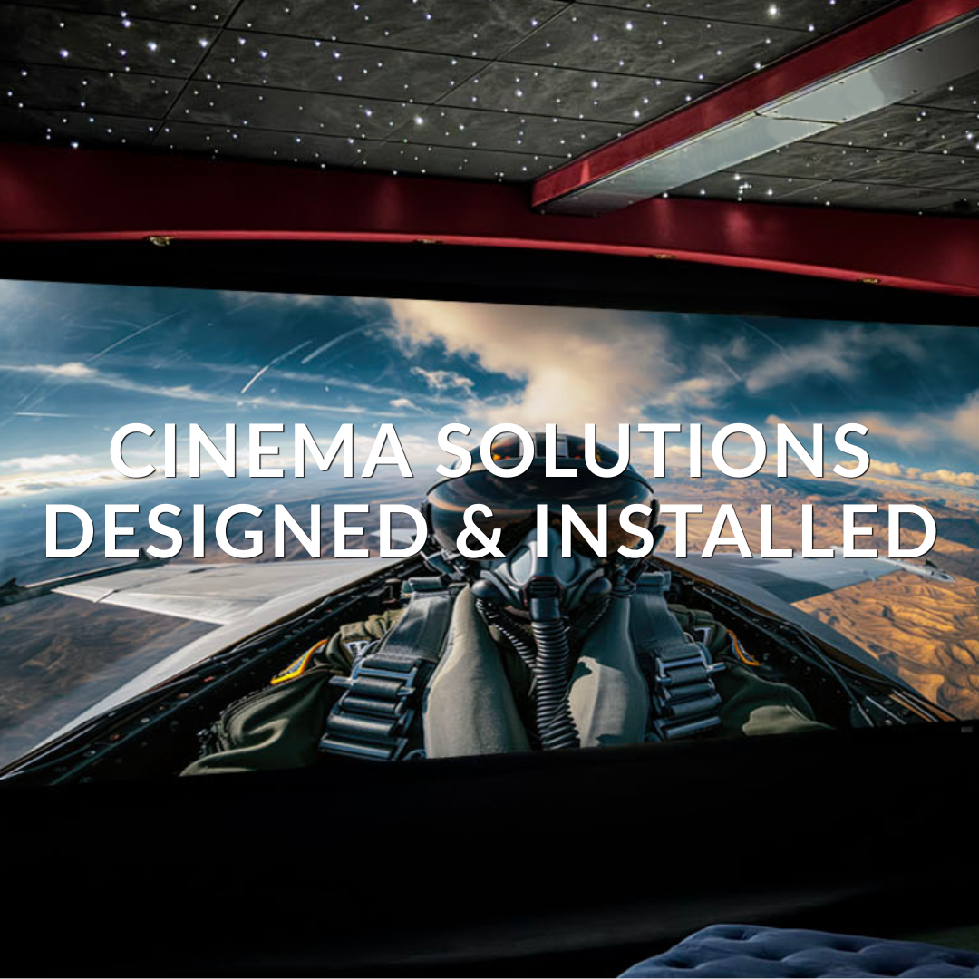 Cinema interior with a screen showing pilot scene, featuring text 'Cinema Solutions Designed & Installed'.