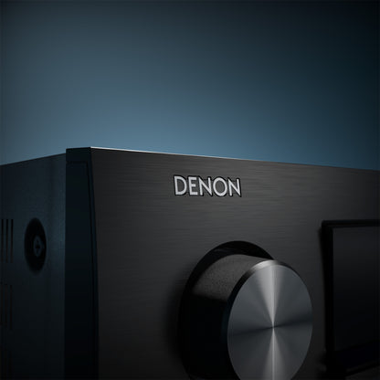 Denon amplifier with a metallic knob on a dark background