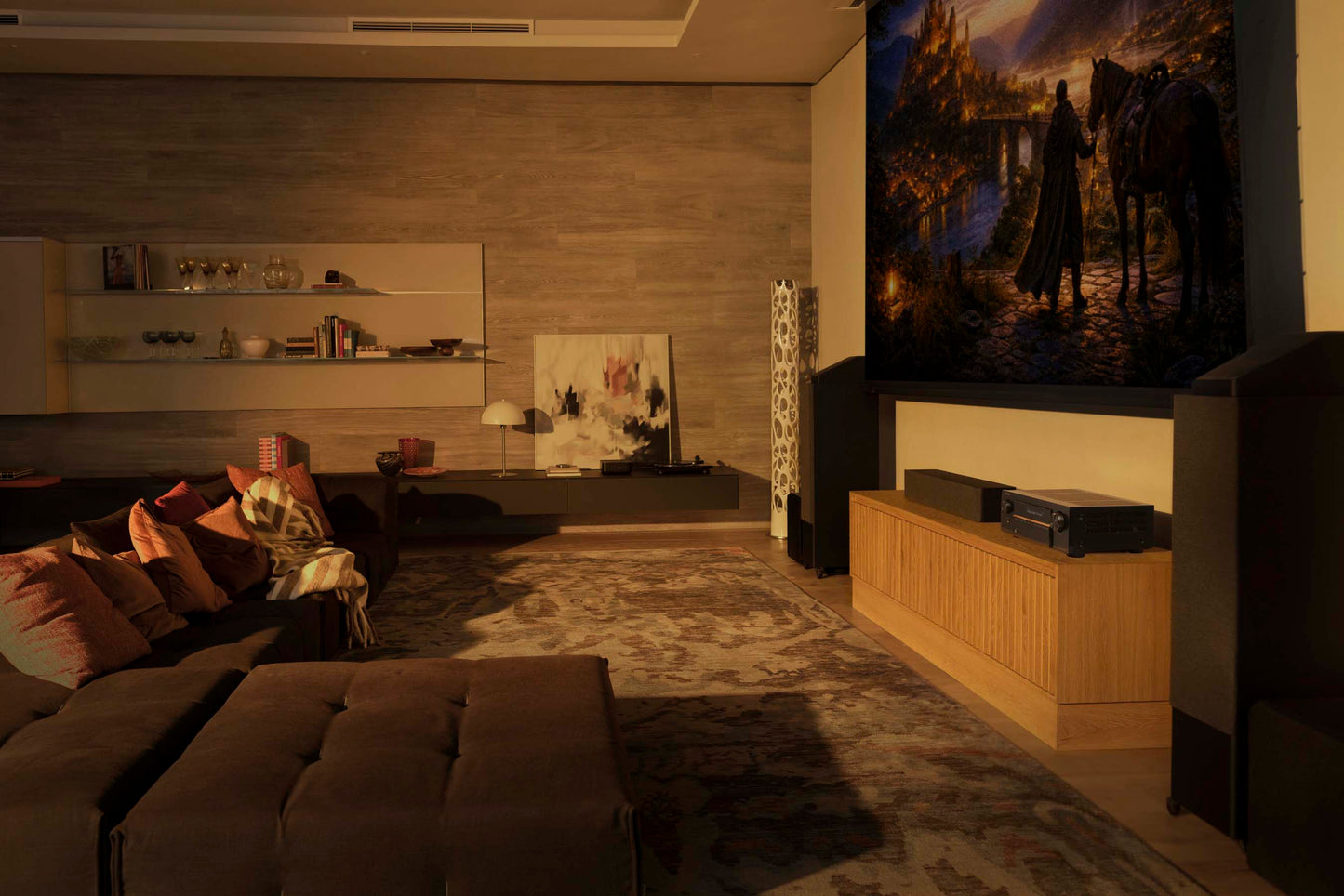 Living room with a large screen displaying a movie scene, surrounded by furniture and decor.