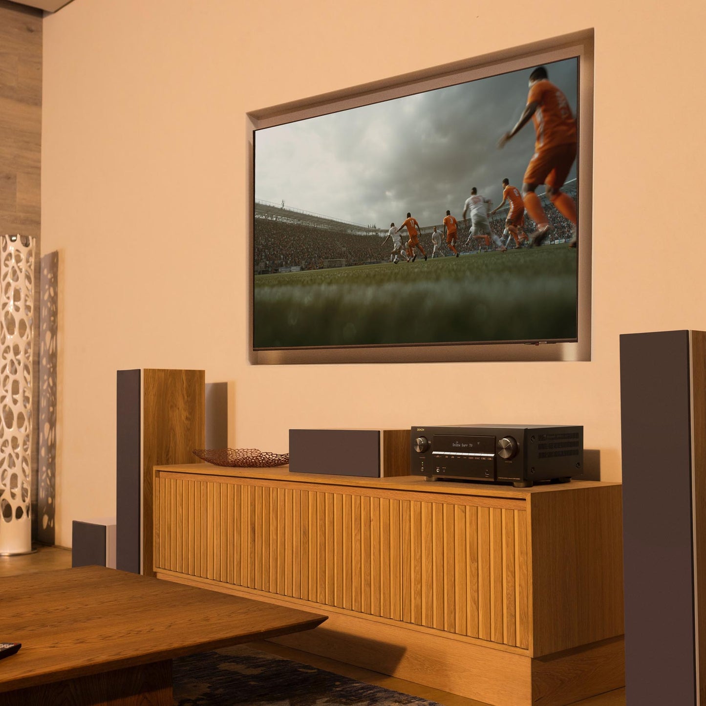 Living room with a TV displaying a soccer game, speakers, and a wooden cabinet.