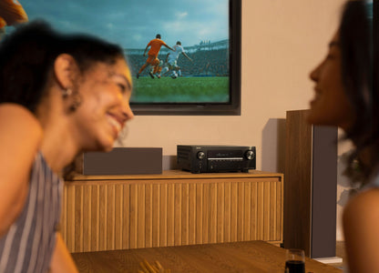 People watching a soccer match on a television in a living room.