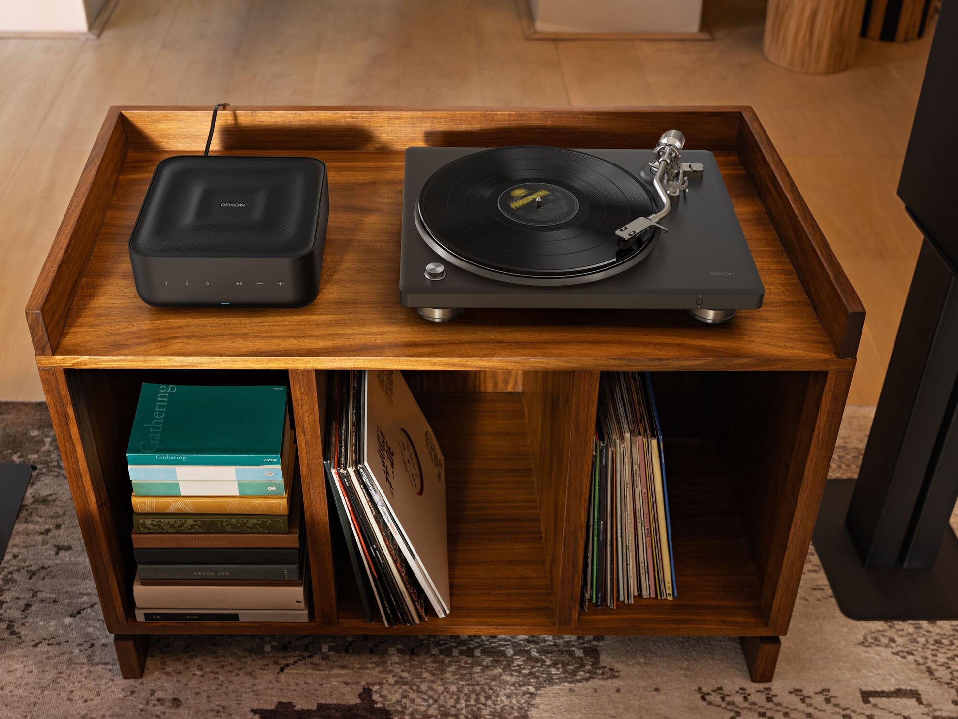 Wooden record player console with turntable and speakers, surrounded by vinyl records.