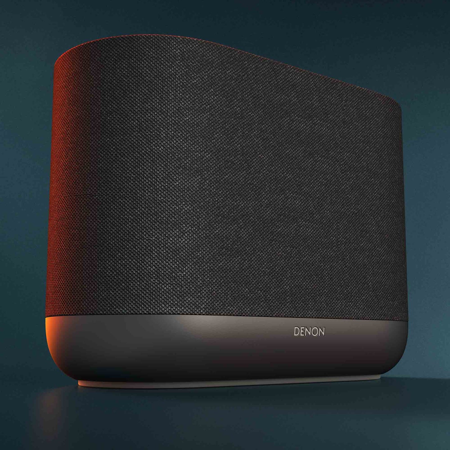Close up of black Denon Home 400 wireless smart speaker on dark green background