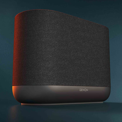 Close up of black Denon Home 400 wireless smart speaker on dark green background