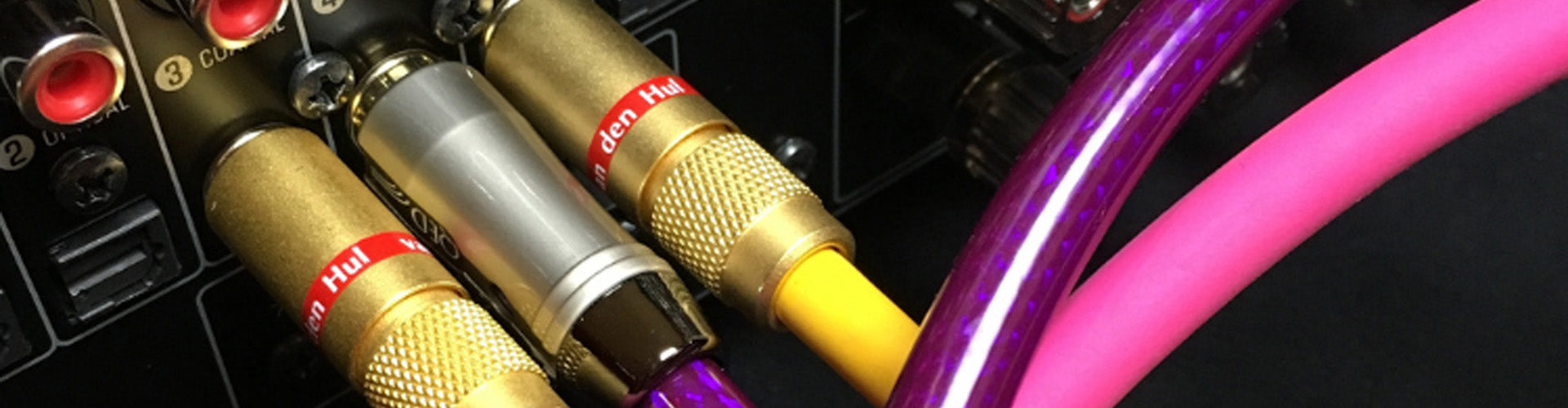 Close-up of audio connectors with gold, silver, and purple cables.