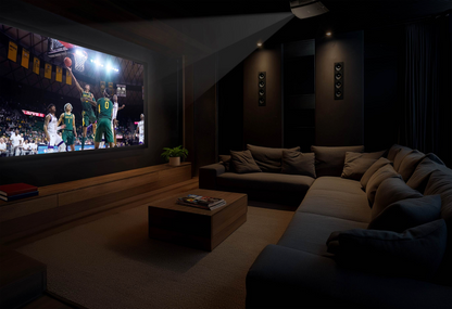 Home theater setup with a large screen displaying a basketball game, surrounded by comfortable seating and dim lighting.