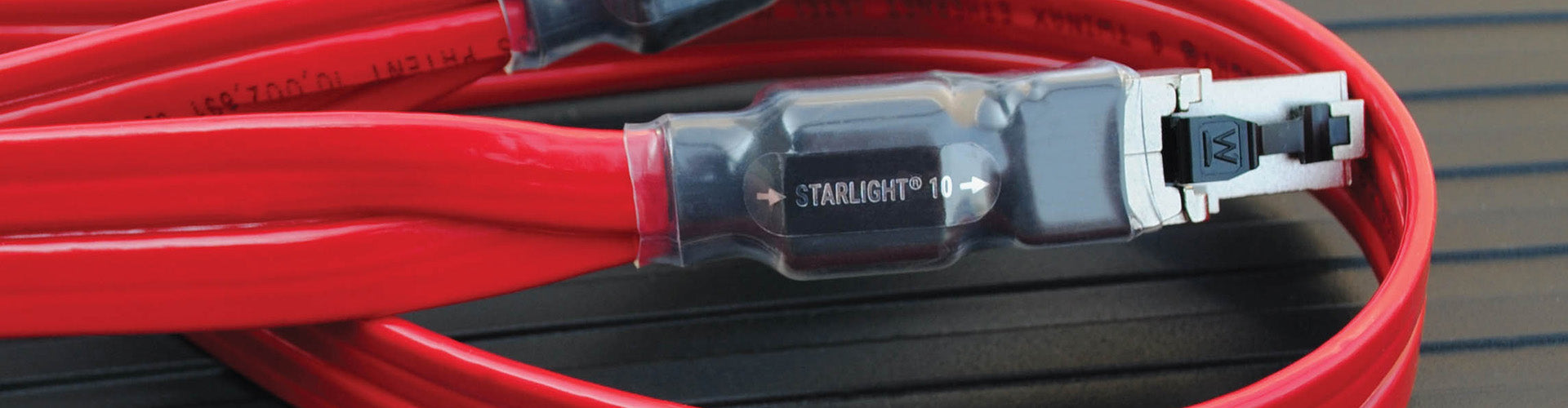 Red electrical cable with a connector on a wooden surface