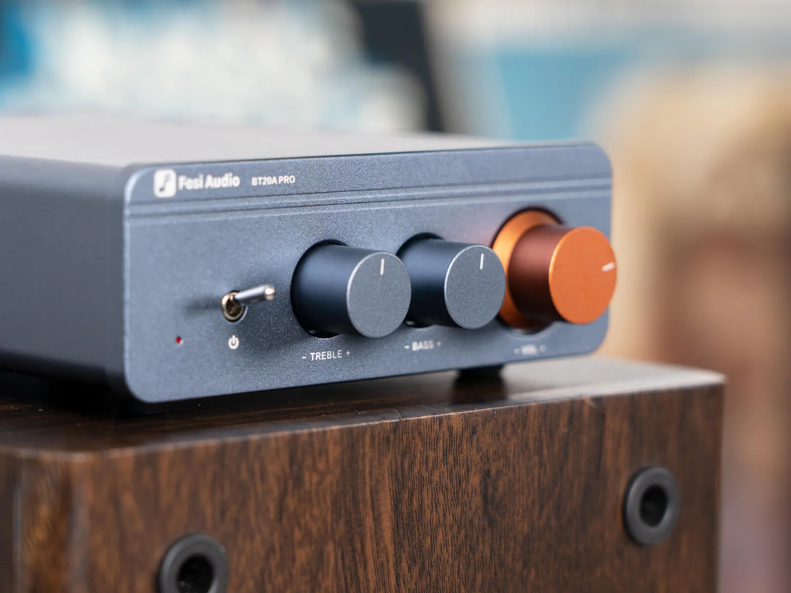 Fosi Audio BT20A Pro Bluetooth Integrated Amplifier sitting on top of a wooden speaker
