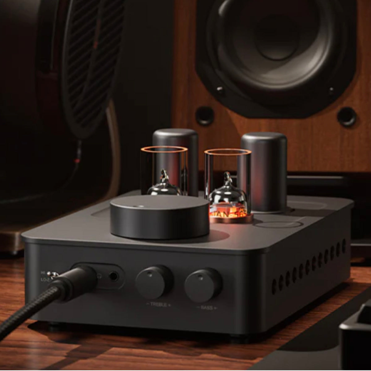Fosi Audio GR70 Tube Headphone Amp Preamp with vacuum tubes on a wooden surface, with speakers in the background.