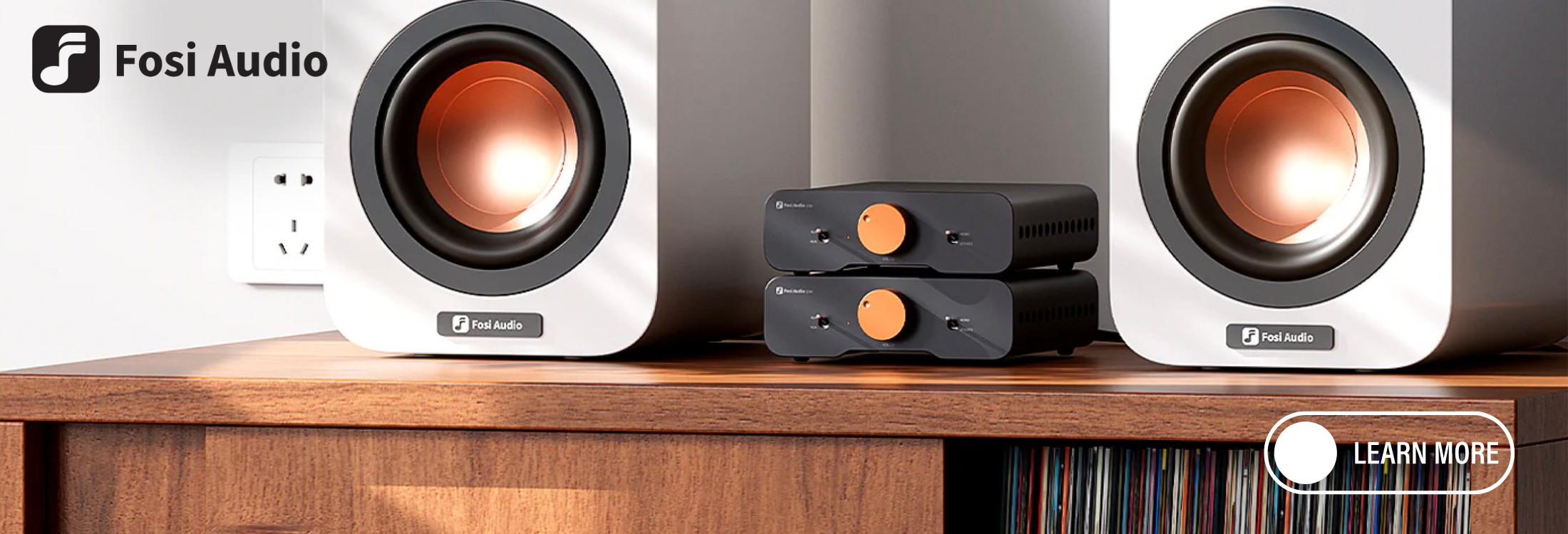 Fosi Audio speakers on a wooden surface with a neutral background