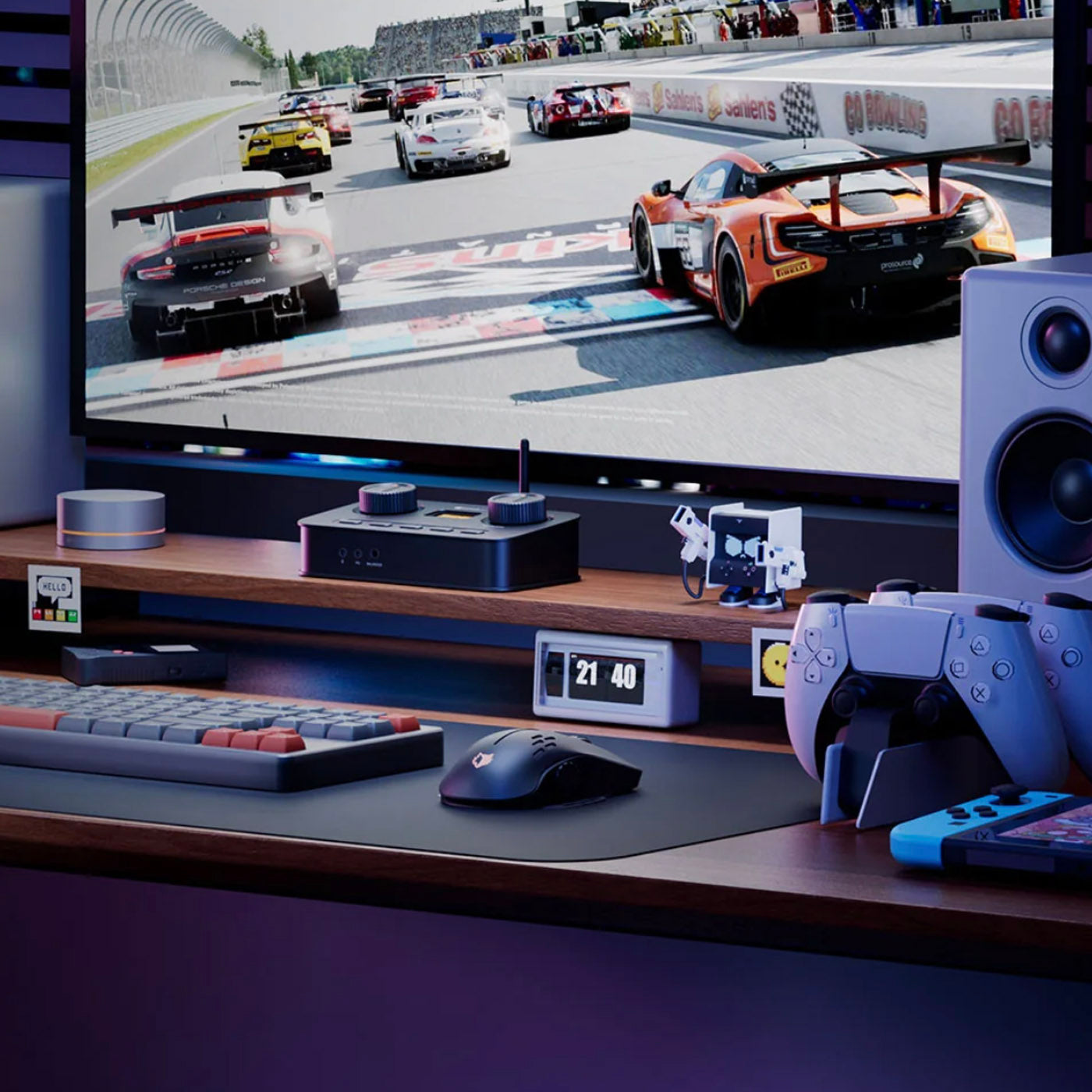 Gaming setup with a monitor displaying a racing game, keyboard, mouse, and gaming console controller on a desk.