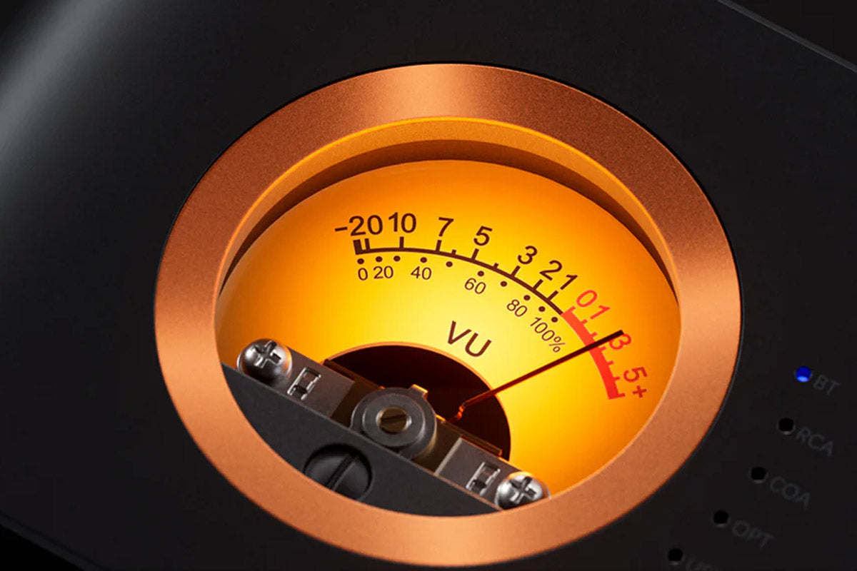 Vintage-style VU meter with a copper rim on a dark background