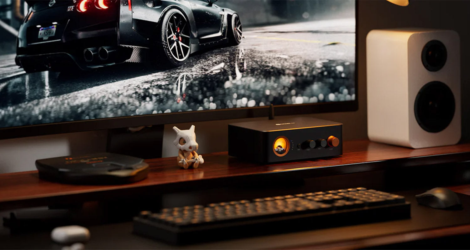 Gaming setup with TV, console, and speakers on a desk