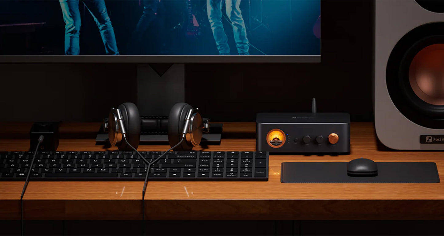 Computer setup with monitor, keyboard, mouse, and speakers on a wooden desk.