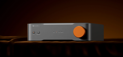 Audio amplifier with orange button on a dark background