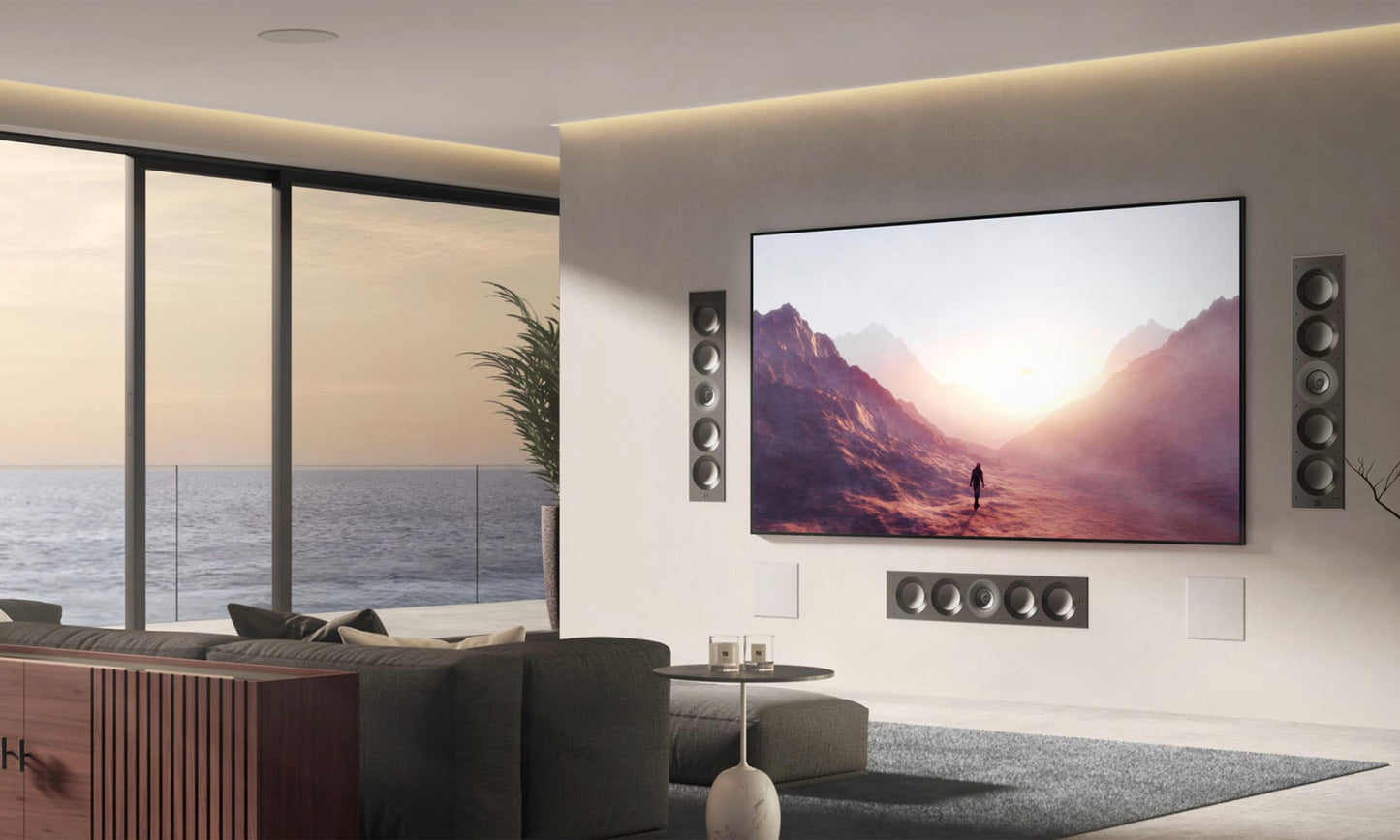 Modern living room with a large TV displaying a scenic image, surrounded by speakers.