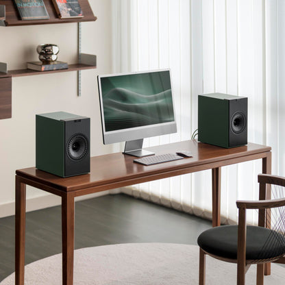 Modern home office setup with a desk, computer monitor, keyboard, and speakers.