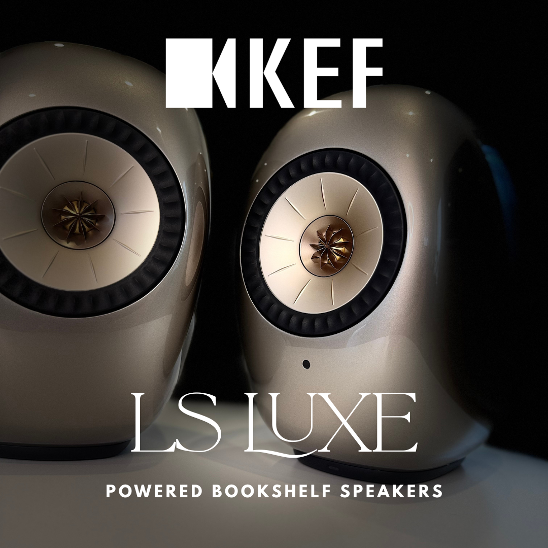 Two KEF LS Luxe powered bookshelf speakers shown against a dark background with the KEF and LS LUXE branding overlaid on the image.