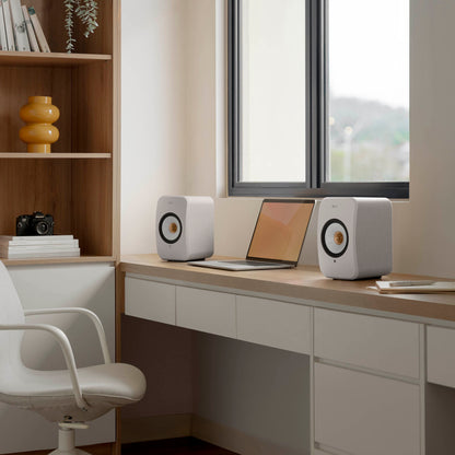 Modern home office with a desk, laptop, and speakers.