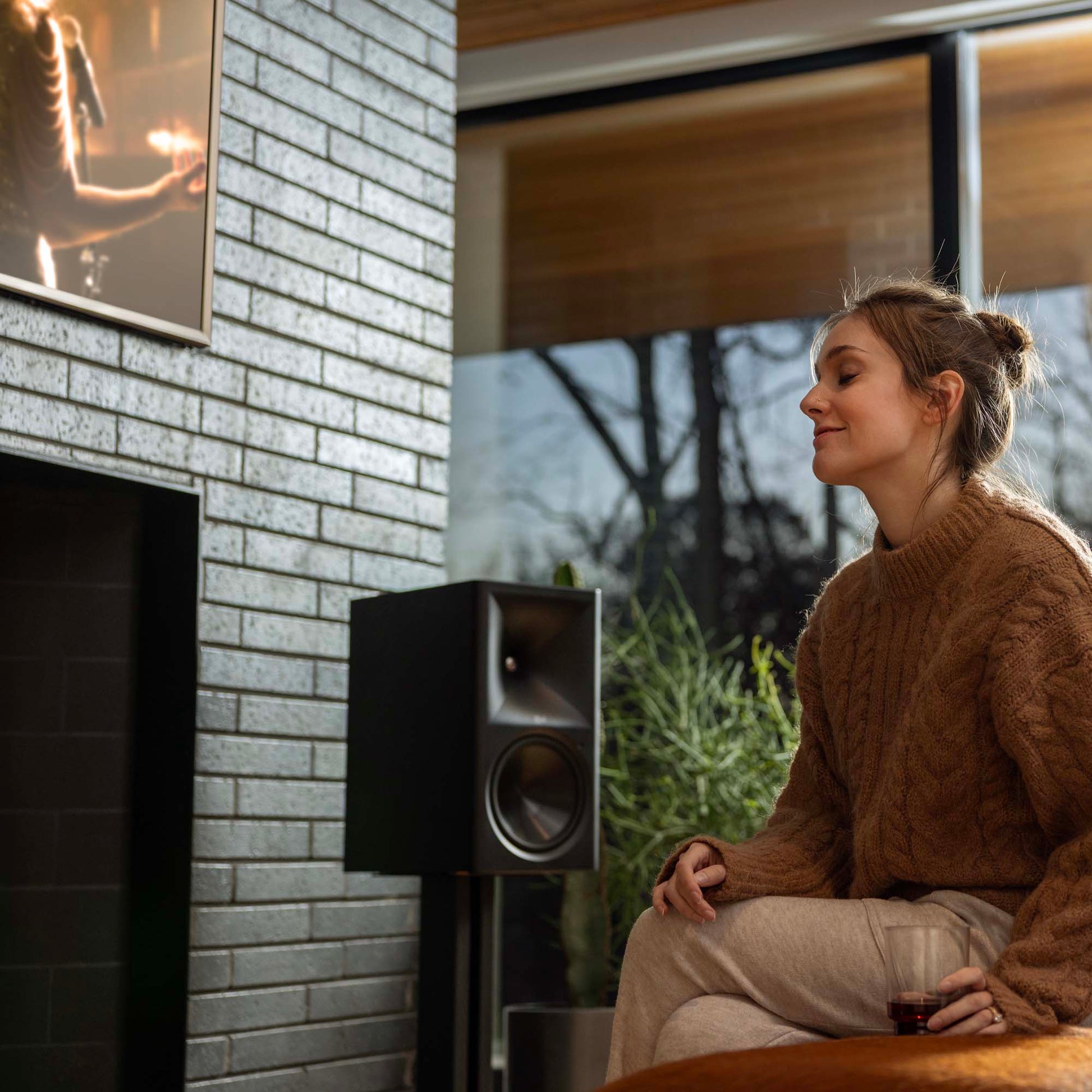 Klipsch The Nines II Powered Speakers in living room with lady sitting next to them