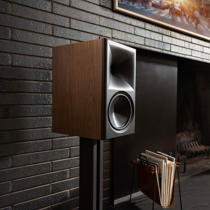 Wooden speaker mounted on a brick wall with a cozy room interior.