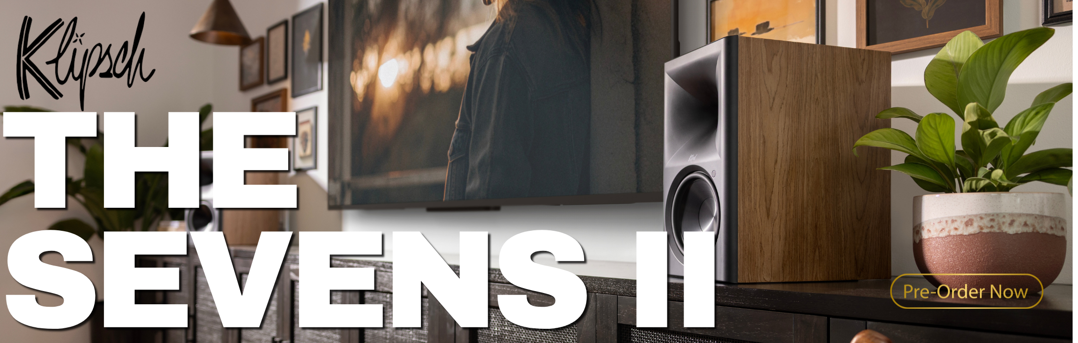 Klipsch The Sevens II speakers with a plant and TV in the background