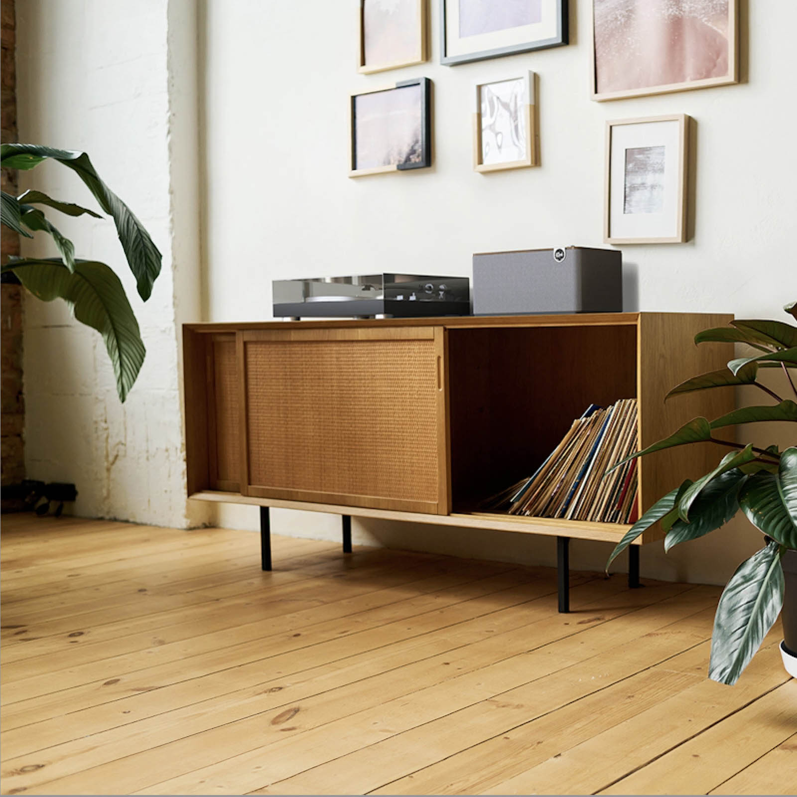 Klipsch The Three Plus Bluetooth Speaker on cabinet with turntable and timber floors