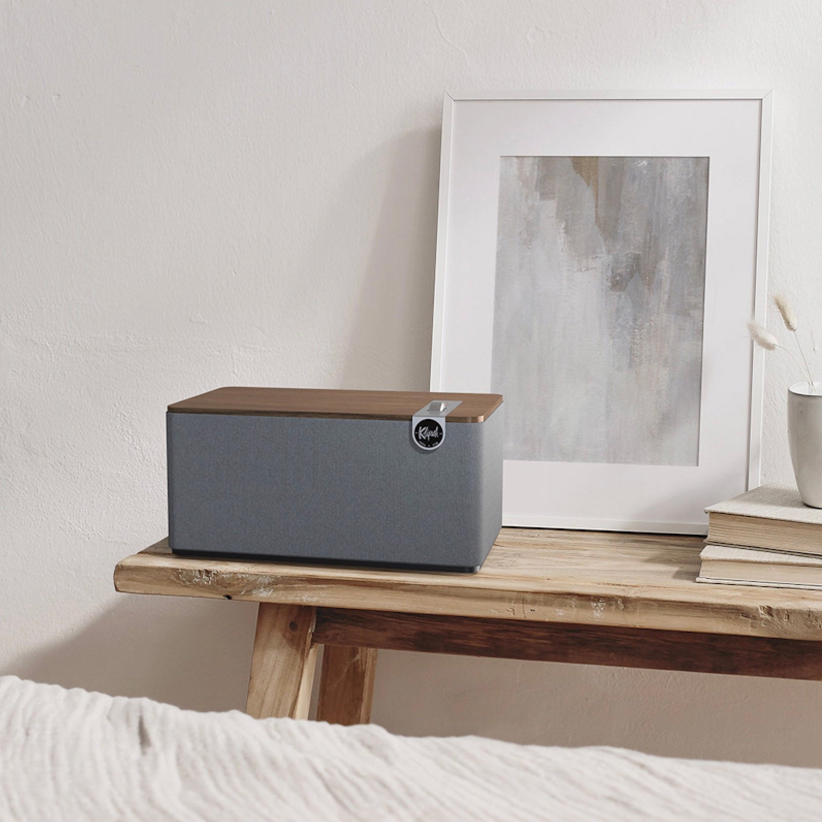 Klipsch The Three Plus Bluetooth Speaker in walnut sitting on bedside table