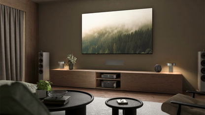 Modern living room with a large TV displaying a nature scene, surrounded by furniture and decor.