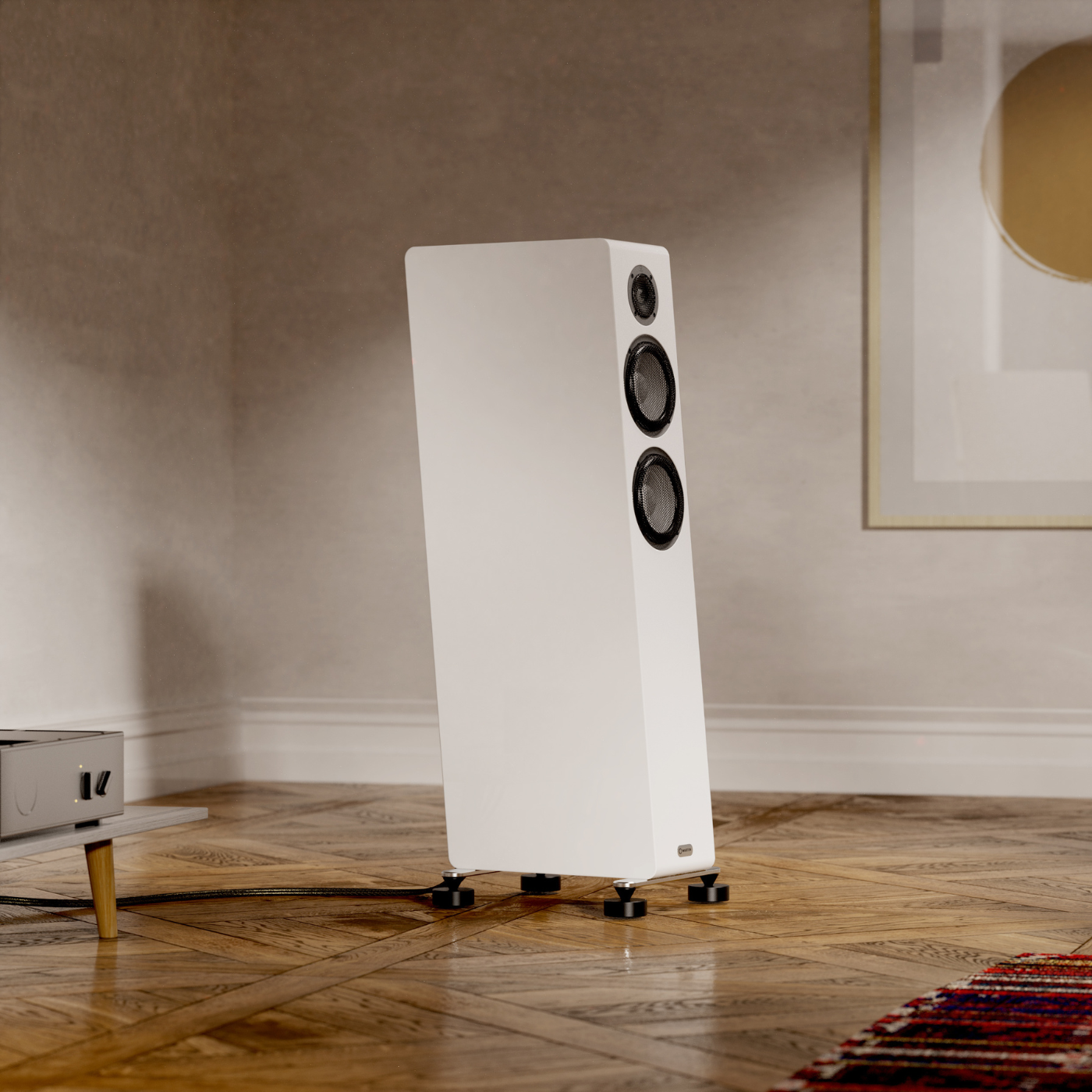White floor-standing speaker in a room with wooden flooring and a neutral wall.