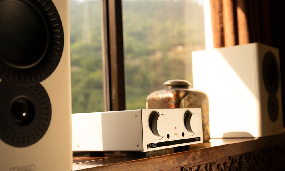 Audio equipment on a wooden surface with a window in the background