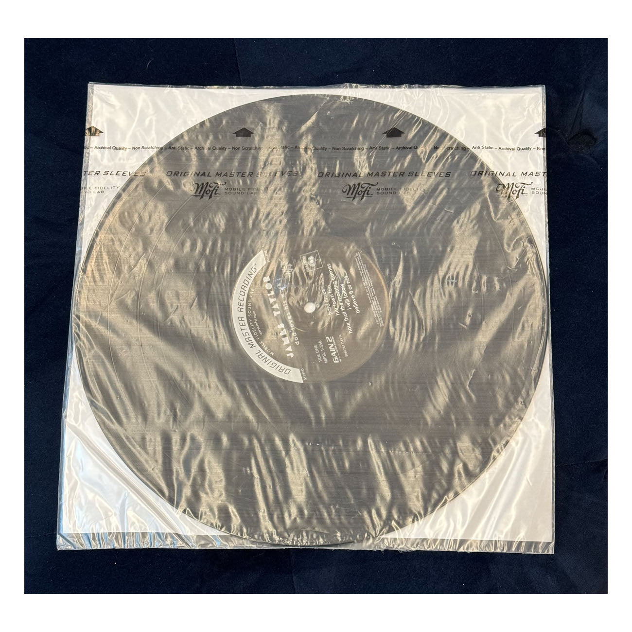 Vinyl record in clear plastic sleeve on a dark background