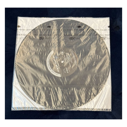 Vinyl record in clear plastic sleeve on a dark background