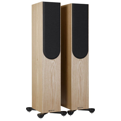 Pair of tall speakers with wooden finish and black accents on a white background