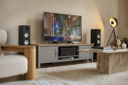 Living room setup with a TV, speakers, and decorative items.