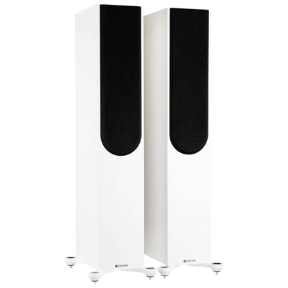Pair of white floor-standing speakers with black grilles on a white background