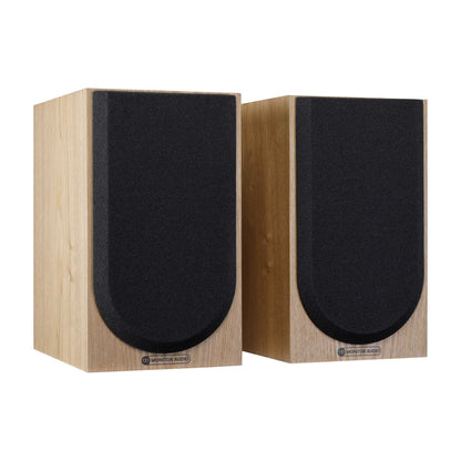 Pair of wooden speakers with black grilles on a white background