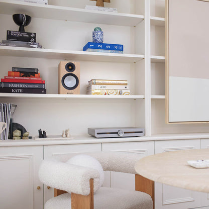Modern home office with shelves, books, and decorative items.