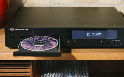 Black CD player with a CD in the tray on a wooden surface