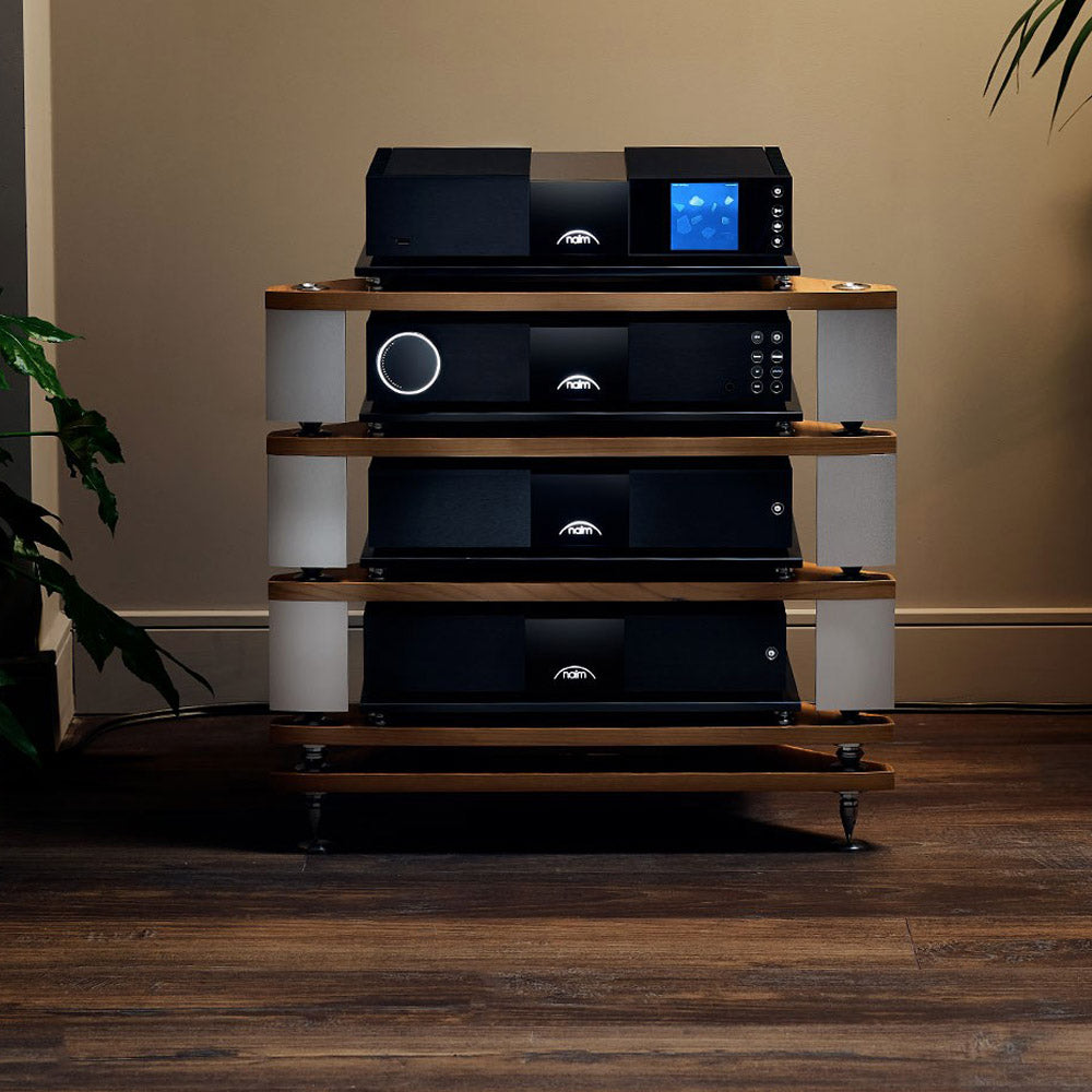 Audio equipment on a wooden stand against a beige wall.