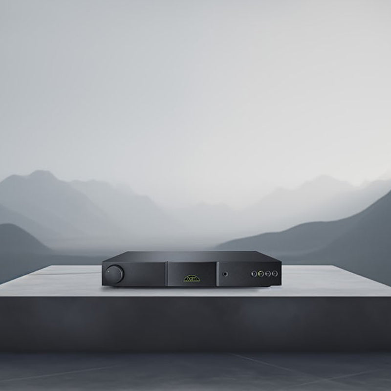 Black electronic device on a reflective surface with a mountainous background