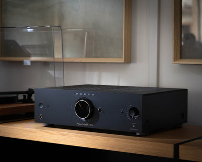 Black audio amplifier on a wooden surface with a blurred background