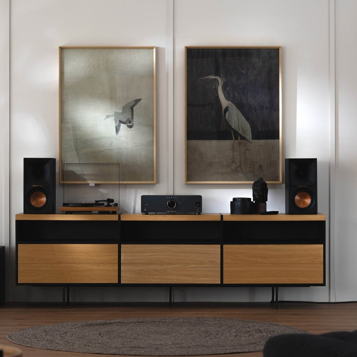 Modern living room with wooden entertainment console, speakers, and wall art.