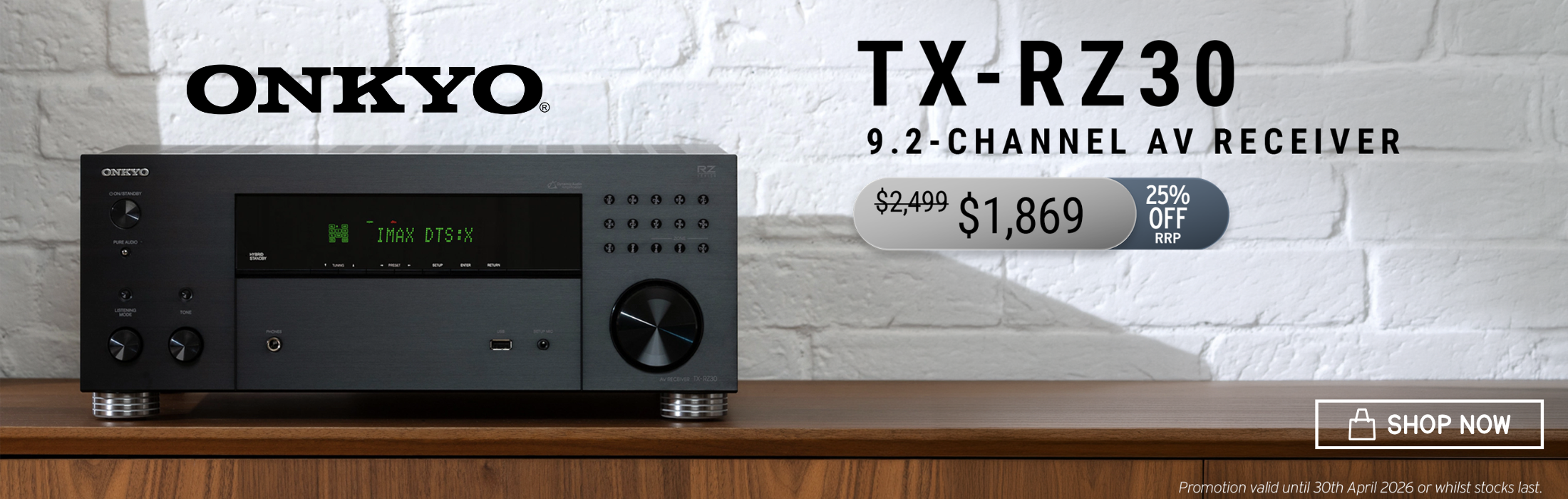 Onkyo TX-RZ30 9.2-channel AV receiver on a wooden surface with a white brick wall background.