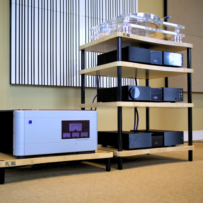 Wooden audio equipment rack with electronic components in a room setting.